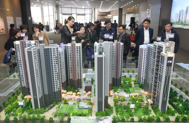 Visitors look at a small-scale model of Xi Apartment built by GS E&C, during a promotion event held in Seoul. (Yonhap)