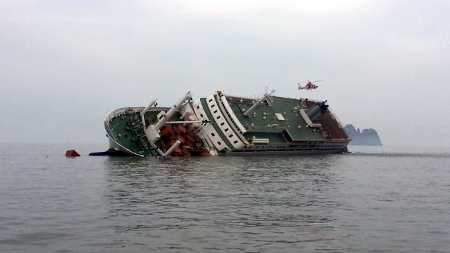 A rescue helicopter flies over the passenger ship Sewol while it sinks with 477 people on board, in waters off South Korea’s southwestern coast on April 16, 2014. (Yonhap)