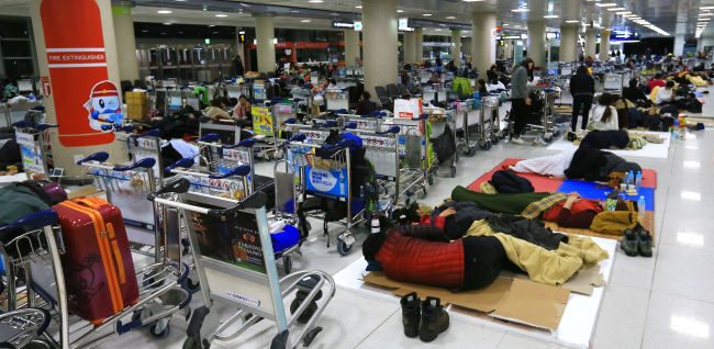 Travelers wait for flights to resume at Jeju Airport in January (Yonhap)