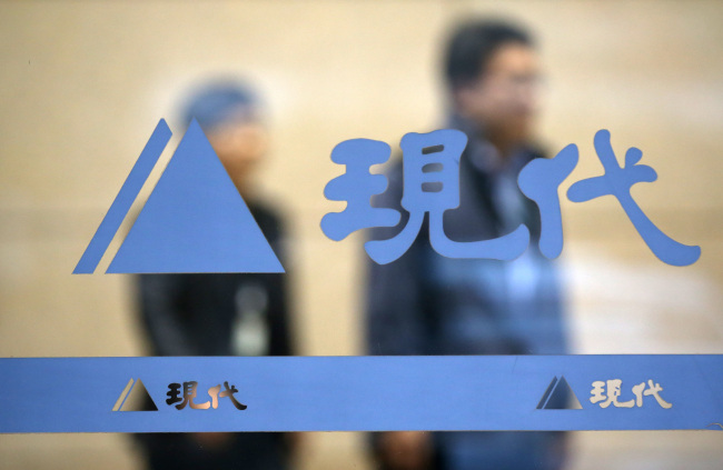 Workers walk pass a glass door at Hyundai Asan headquarters in Seoul. (Yonhap)