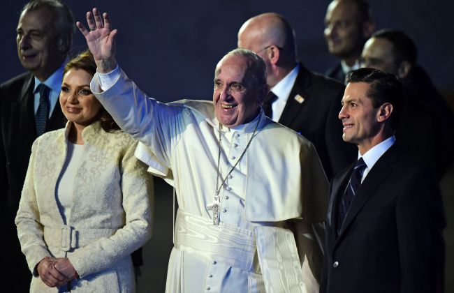 Pope Francis (center) waves next to Mexican President Enrique Pena Nieto (right) and First Lady Angelica Rivera (left) upon his arrival at Benito Juarez international airport in Mexico City on Friday (local time). (AFP Photo)