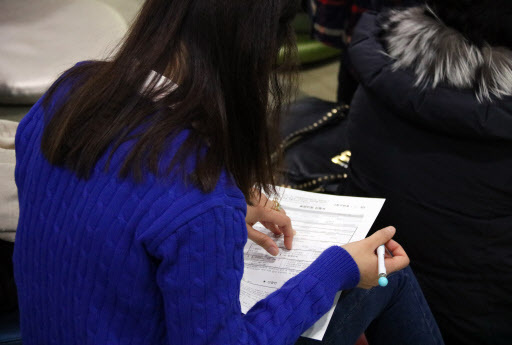 A job seeker fills out an application form for unemployment allowance in Seoul. (Yonhap)