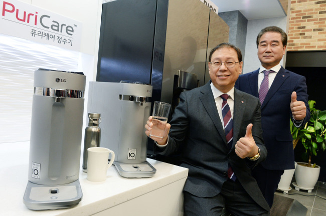 LG’s appliance chief and president Cho Seong-jin (left) poses next to the company’s new PuriCare water purifiers at a launch event in Seoul on Wednesday. LG Electronics