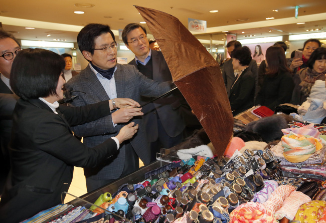 Prime Minister Hwang Kyo-ahn browses through items during a sale promoting Gaeseong industrial park products at Lotte Department Store in Seoul on Sunday. Yonhap