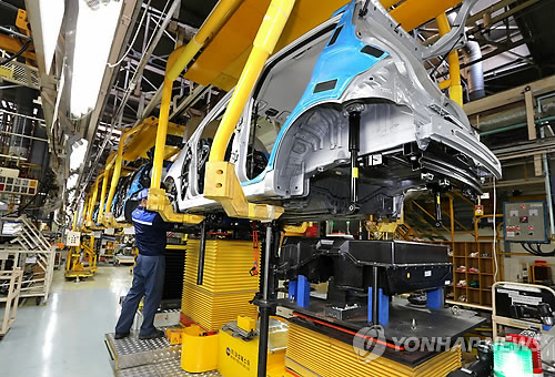 Workers assemble a car at a local auto plant. (Yonhap)