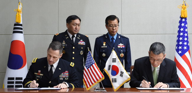 South Korea's Deputy Defense Minister Yoo Jeh-seung(right) and U.S. Army commander Lt. Gen. Thomas S. Vandal sign an agreement on composition and operation of the joint working group on THAAD talks at the ministry compound in Seoul on Friday. (Yonhap)