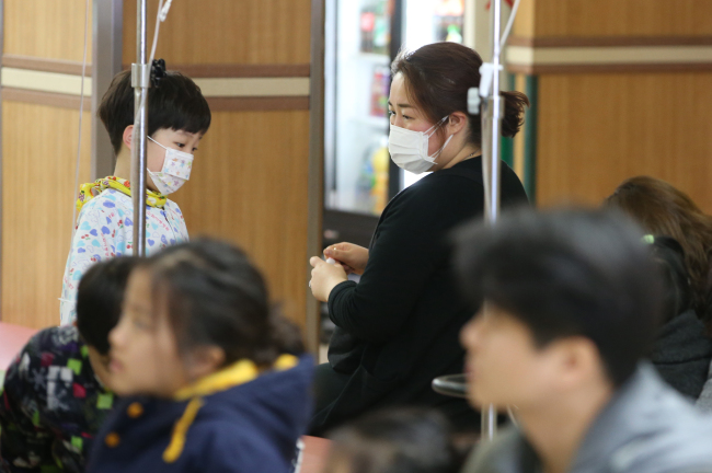 Patients covered with masks wait to see doctor at a hospital in Seoul. (Yonhap)