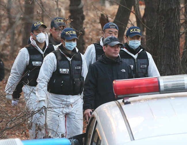 Police carry the body of 7-year-old Shin Won-young from a mountain in Pyeongtaek, Gyeonggi Province, on Saturday. Yonhap