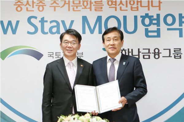 Hana Financial chairman Kim Jeong-tae (right) poses with Minister of Land, Infrastructure and Transport after agreeing to provide its unused branches for the ministry‘s New Stay rental program at KEB Hana Bank’s branch in Seoul on Friday. (Hana Financial)