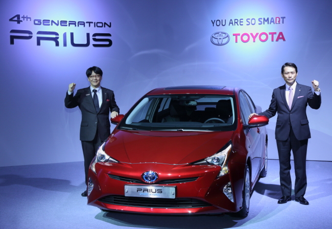 TOYOTA PRESENTS FUTURE OF HYBRID WITH NEW PRIUS-- Toyota Korea CEO Akihisa Yoshida (right) poses next to the fourth-generation Prius hybrid at its launch event at Westin Chosun Hotel in Seoul on Tuesday. (Toyota Korea)