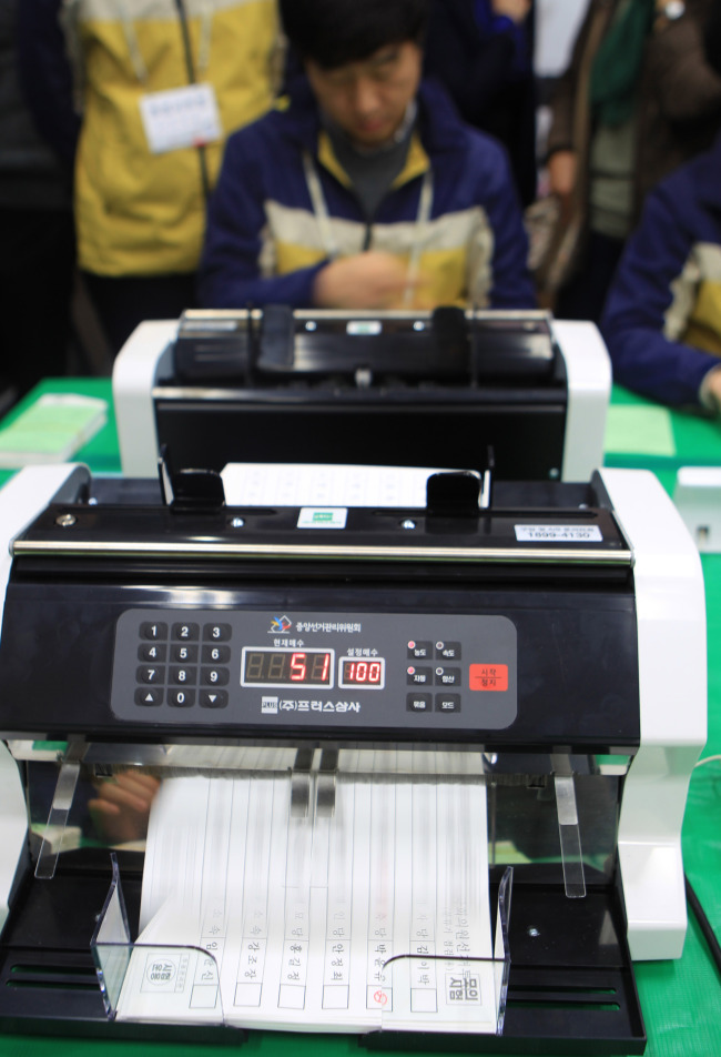 Officials demonstrate the ballot-counting machine at the National Election Commission’s district office in Changwon on March 17. Yonhap