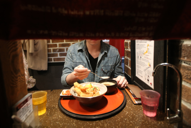 A man is eating alone at a restaurant specially designed for “honbobjok,” people who eat alone, in Sinchon, Seoul. Yonhap