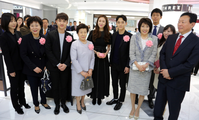 LOTTE’S DUTY-FREE STORE IN GINZA -- Lotte Group chairman Shin Dong-bin (far right) and his family, including his sister and chairwoman of the Lotte Foundation Shin Young-ja (second from left), his daughter-in-law and son Shin Yoo-yeol (second and third from right) pose for the press on Thursday at the opening of Lotte Duty Free Ginza in Tokyo, Japan. Also present are actress Choi Ji-woo (fifth from left), EXO’s D.O. (third from left) and Chen (sixth from left). (Yonhap)