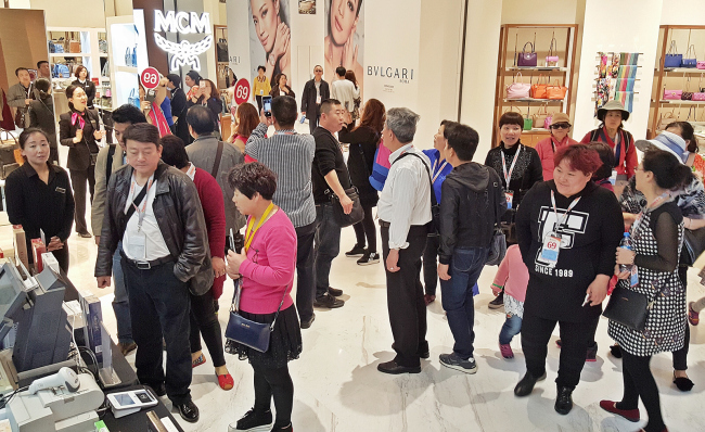 CHINESE SHOPPERS CRUISE TO BUSAN -- Chinese tourists shop at the newly opened Shinsegae Duty Free in Shinsegae Department Store’s Centum City branch in Busan. About 2,100 Chinese tourists arrived in the southern port city on Thursday on the 168,000-ton cruise ship Quantum of the Seas. (Yonhap)