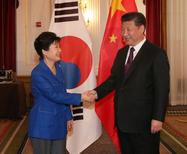 South Korean President Park Geun-hye shakes hands with Chinese counterpart Xi Jinping at summit talks in Washington on Thursday. (Yonhap)