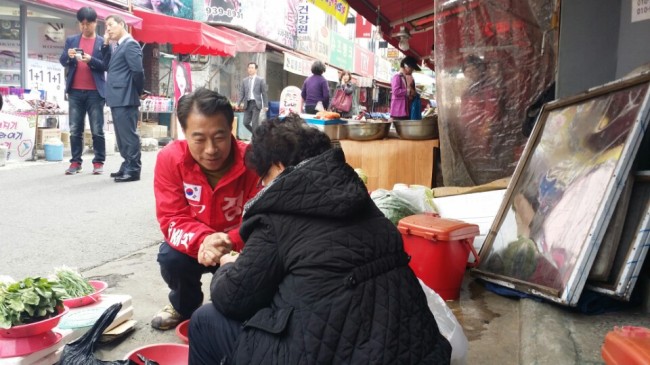 Saenuri’s Chong Jong-sup talks to a seller at a market on his campaign trail in Daegu. Yeo Jun-suk/The Korea Herald