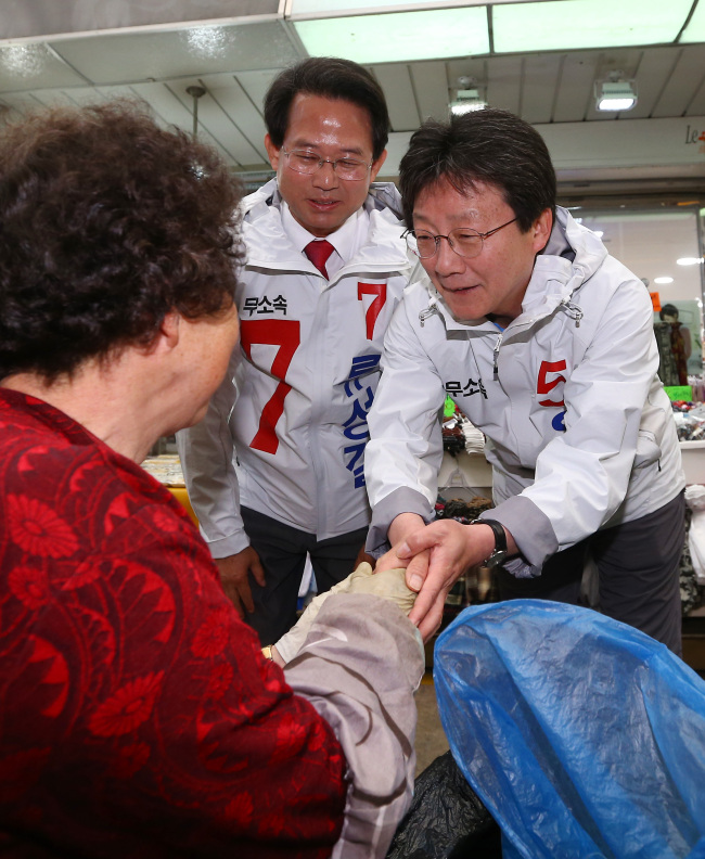 Independent runner Yoo Seong-min shakes hands with citizens in Daegu. (Yonhap)