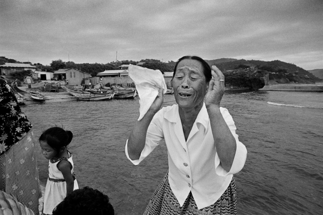 An elderly mother wails during a shamanic ritual to retrieve the soul of her son, who died during a sea storm, and send it on its way to heaven, in Pohang, North Gyeongsang Province, in 1981. (Photograph by Kim Soo-nam/The National Folk Museum of Korea)