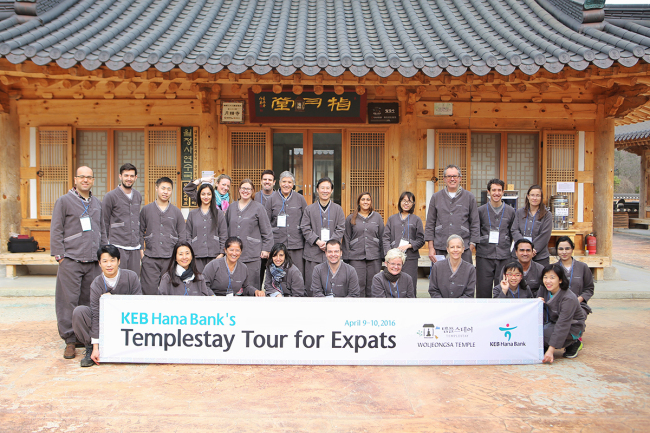 TEMPLESTAY FOR KEB HANA CLIENTS -- A group of expats who joined KEB Hana Bank’s Templestay Tour pose in traditional temple attire at Woljeongsa Temple, Gangwon Province, on Saturday. The bank said Monday that nearly 30 customers from 14 countries have participated in the two-day program held in partnership with the Jogye Order of Korean Buddhism. (KEB Hana Bank)