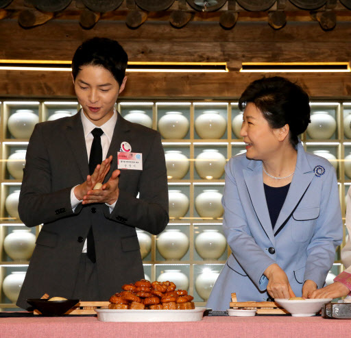 SWEET DESSERTS -- President Park Geun-hye (right) and actor Song Joong-ki -- Korea‘s tourism ambassador -- make a traditional Korean dessert during the opening ceremony of the K-Style Hub, located at Korea Tourism Organization’s headquarters in central Seoul on Monday. (Yonhap)