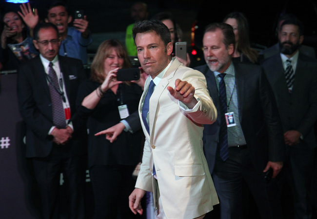 Actor Ben Affleck, cast as Batman, waves as he arrives for the red carpet event promoting 