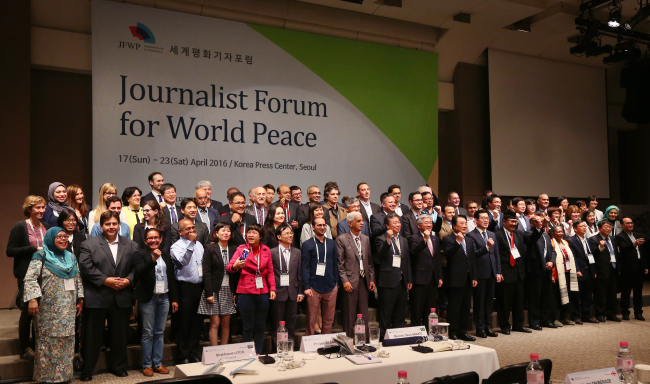 Participants pose at the opening ceremony of the Journalist Forum for World Peace in Seoul on Monday. (Yonhap)