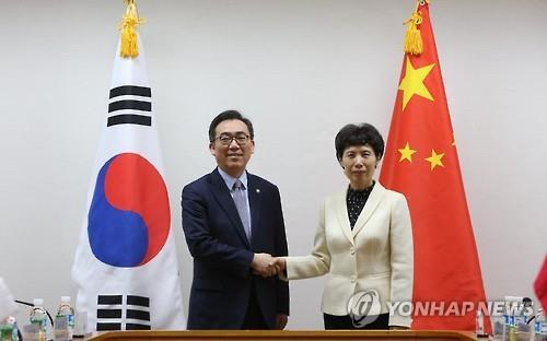 Second Vice Foreign Minister Cho Tae-yul (L) shakes hands with Chinese Vice Commerce Minister Gao Yan (R) before their talks at the foreign ministry building in Seoul on April 20, 2016. (Yonhap)