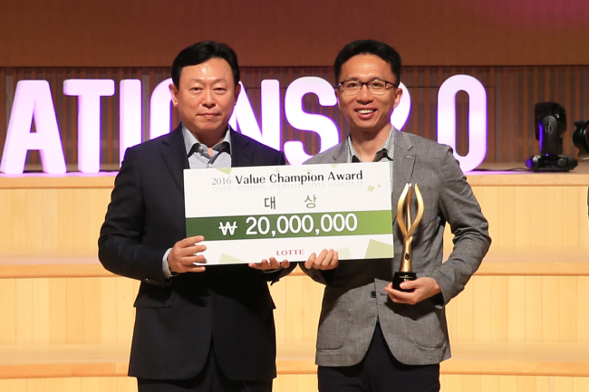 VALUE CHAMPION -- Lotte Group chairman Shin Dong-bin (left) poses with Ji Sang-hoon, leader of the polycarbonate production team at Lotte Chemical’s Yeosu factory, who won the Value Champion Award for contributing to the group’s efforts in saving energy and enhancing productivity, at the annual HR Forum at Lotte Concert Hall in Jamsil, Seoul, on Monday. (Lotte Group)