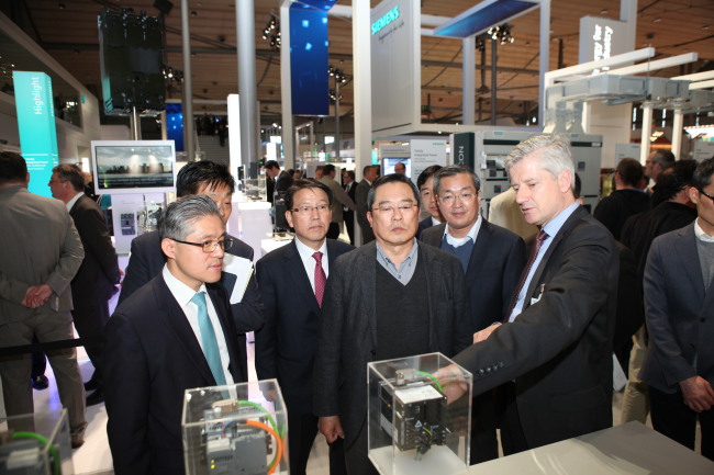 LS Group chairman Koo Cha-yol (center) listens to Ralf Christian (right), CEO of Energy Management Division at Siemens, during Hannover Messe this week. (LS Group)