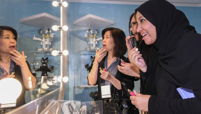 Representatives from the Association of Southeast Asian Nations try Korean cosmetics products at the Coreana Cosmetics Museum in Seoul on Saturday. (ASEAN-Korea Center)