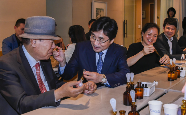 ASEAN-Korea Center secretary general Kim Young-sun tries a perfume at the Coreana Cosmetics Museum in Seoul on Saturday (ASEAN-Korea Center)