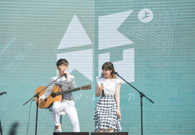 Akdong Musician’s Lee Chan-hyuk (left) and Lee Soo-hyun perform at Seoul Forest on Friday, May 5. (YG Entertainment)