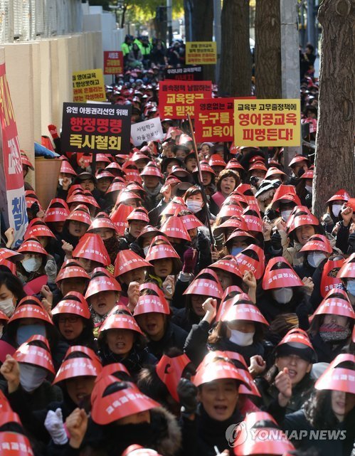 Parents of private elementary school students in Seoul hold a rally against the government’s decision to ban immersion education in November 2013. Yonhap