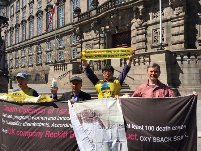 Victims and members of civic groups hold a rally in front of the Danish Parliament on Monday, local time. (Yonhap)