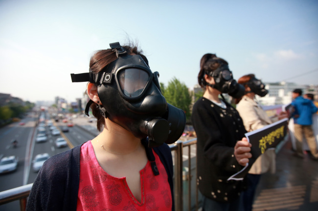 Members of civic groups stage a rally calling for measures to curb fine dust in Seoul on Monday. Yonhap