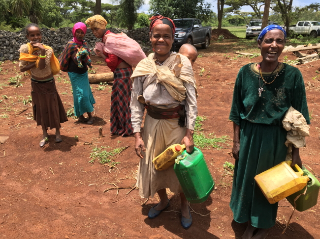 Fatima Surel (center), a 30-year-old resident in the southwestern town of Adoshe, and other villagers pose after obtaining water from a stream on May 3 in Gurage Zone, Ethiopia. (Shin Hyon-hee/The Korea Herald)