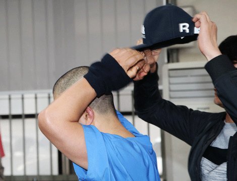 The brother tried to show his face to the media. (Yonhap)