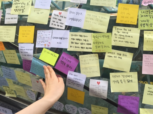 Visitors pay tribute to a 23-year-old woman in an alleged hate crime, near exit 10 of Gangnam Station on Wednesday. (Claire Lee/ The Korea Herald)