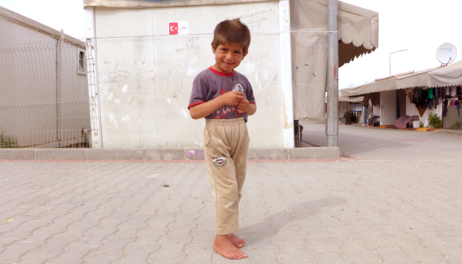 A Syrian child saunters in a refugee camp in Turkey near Gaziantep. He is one of 270,000 people housed in temporary accommodation centers across the country, which has received 2.75 million Syrians since 2011. (Joel Lee/The Korea Herald)