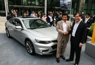 POSCO chairman Kwon Oh-joon (right) shakes hands with GM Korea CEO James Kim in front of the all-new Malibu built with POSCO’s steel products. The steelmaker allowed the carmaker to display its new mid-sedan in front of the steelmaker’s Seoul office, located in Daechi-dong, southern Seoul, Monday, for a joint-marketing effort. (GM Korea)