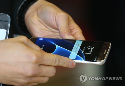 An individual uses Samsung Electronics’ Galaxy S7. (Yonhap)