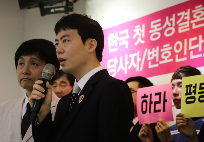 Gay Korean couple Kim Jho Gwang-soo, 51, and his partner Kim Sung-hwan, 32, make remarks in a press conference held in Jongno-gu, central Seoul, to criticize a court’s refusal to recognize same-sex marriage. Yonhap