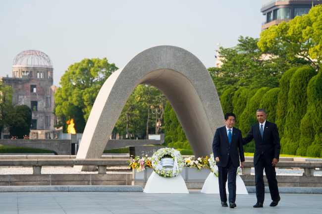 US President Barack Obama (right) and Japanese Prime Minister Shinzo Abe turn around after laying wreaths during a visit to the Hiroshima Peace Memorial Park in Hiroshima on Friday. (AFP-Yonhap)