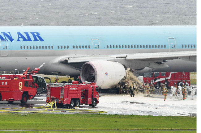 Korean Air`s Boeing 777-300 jet is seen at Haneda Airport in Tokyo on Friday after fire at its left-side engine is extinguished. (Yonhap)