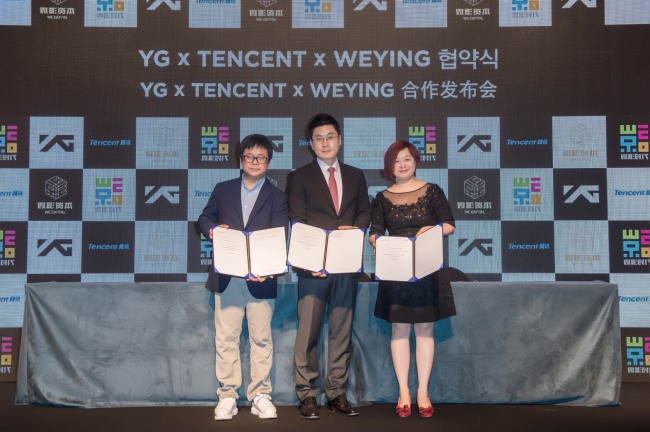 From left: Weiying CEO Ning Lin, YG Entertainment CEO Yang Min-suk and editor in chief of Tencent Video Wang Suman pose with the signed agreements at the end of a ceremony announcing the business collaboration among the three companies in Seoul on Tuesday. (YG Entertainment)