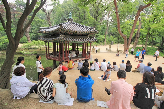 Participants listen to excerpts of Shakespeare’s “Hamlet,” as part of the special tour “A Walk with Hamlet and Jeongjo” at Changdeokgung Palace’s Secret Garden on May 29. (Julie Jackson/The Korea Herald)