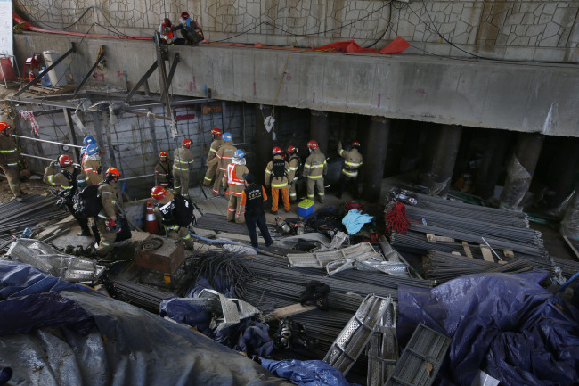 Firefighters work on a site where an explosion and a collapse killed four and injured 10 workers on Wednesday in the city of Namyangju, east of Seoul. (Yonhap)