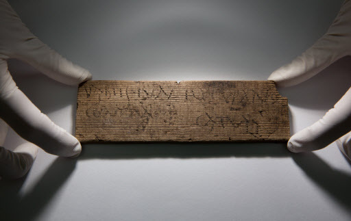 Museum of London Archaeology archaeologist Luisa Duarte poses with a Roman waxed writing tablet dated A.D. 80-90/5 at Bloomberg’s offices in London on Wednesday. (AFP-Yonhap)