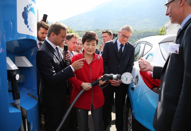 South Korean President Park Geun-hye (center) fuels hydrogen gas into Hyundai Motor’s Tucson Fuel Cell vehicle during her visit to a research facility operated by French industrial gas supplier Air Liquide in Grenoble, France on Saturday. (Yonhap)