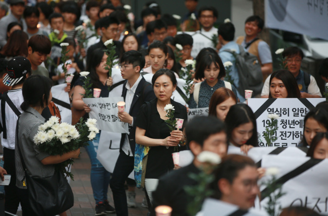 Citizens march in a rally on Saturday in tribute to a subway worker who was killed while repairing a screen door at Guui Station on May 28, sparking heated debate over the unfair treatment of irregular workers. (Yonhap)